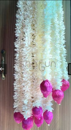 some pink and white flowers hanging from a ceiling