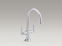 a kitchen faucet with two handles and nozzles on the side, against a gray background