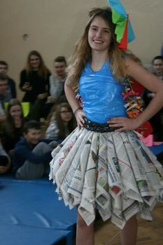 a woman in a dress made out of newspapers and magazine pages is standing with her hands on her hips