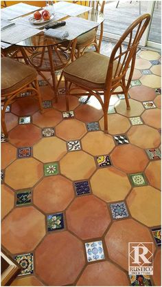 a dining room table and chairs with colorful tiles on the floor