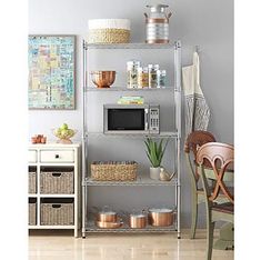 a kitchen shelving unit with pots and pans on the top shelf, next to a microwave