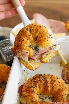 ham and cheese bagels being lifted from a tray