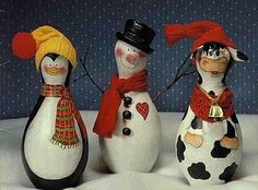 three snowmen with hats and scarves are standing in the snow