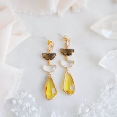 "These gorgeous boho bridal earrings feature unique faceted yellow drops which are reminiscent to flower petals or even fluttering butterfly wings! These eye catching statement earrings are the perfect accessory for wearing in an updo hair style for your boho wedding, a birthday gift for your best friend or to add a touch of sparkle for a special occasion this summer! These dangle earrings are created with sterling silver and oval faceted glass with a golden frame. Your beautiful yellow and hazel brown earrings will arrive suitably gift wrapped ready for gift giving. Measurements: The length of the boho bridal earrings hang just under 2.5\" long Metals: 18k gold plated brass  925 sterling silver plated earring posts For a similar pair of earrings with pink and hazel brown: https://www.etsy Faceted Yellow Jewelry For Wedding, Yellow Dangle Crystal Party Earrings, Yellow Dangle Crystal Earrings For Party, Elegant Yellow Faceted Earrings, Yellow Teardrop Earrings For Wedding, Faceted Drop Earrings For Wedding, Yellow Wedding Earrings With Ear Wire, Yellow Ear Wire Earrings For Wedding, Yellow Earrings With Ear Wire For Wedding