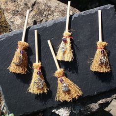 four small tassels with bells on them sitting on top of a black rock