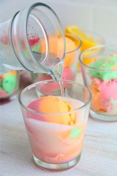 rainbow sherbet punch is being poured into small glasses