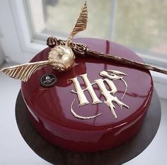 there is a red cake with gold decorations on the top and an emblem on the bottom