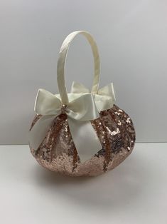 a white and gold sequin purse with a bow