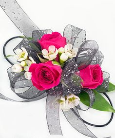 a bouquet of pink roses and white orchids on a silver ribbon tied to a bow