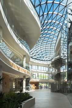 the inside of a large building with lots of windows and plants in it's center