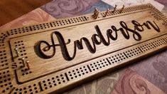 a wooden sign that says anderson on the front and back of it, with pins in each corner