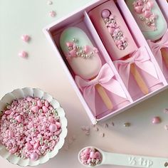 three pink and white decorated items in a box