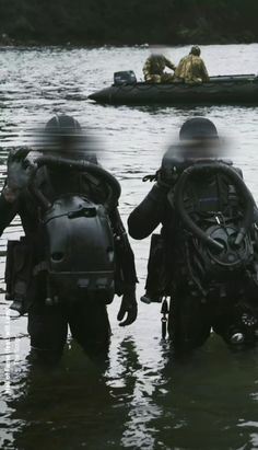 two men in wetsuits are standing in the water