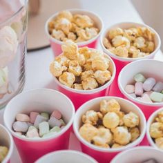 several cups filled with marshmallows and candy