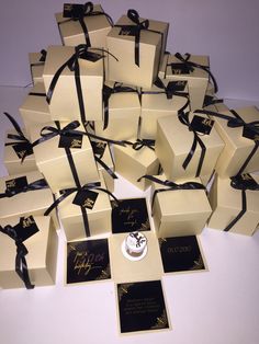 a pile of white boxes with black ribbons and tags tied around the top one box has a clock on it