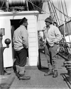 two men standing on the deck of a ship