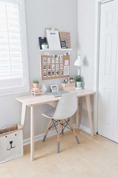 a white desk with a chair next to it and some pictures on the wall behind it