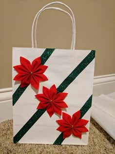 a paper bag decorated with red flowers and green glitters on the side, sitting on carpet