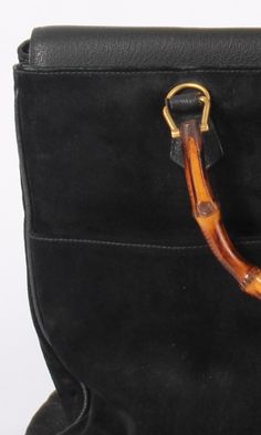 OR 4 interest-free installments of $147.50 USD by Vintage Gucci handbag. Black suede with pebbled leather trim, top flap and bottom panel. Natural bamboo handles. Top flap with double magnetic snap closure. Two exterior front pockets Gold brass hardware. 5 metal feet on bottom. Two large interior compartments, & two inner zip pockets. Bag Dimensions (inches): 14 W x 11 H x 6 D. Handles: 4.5" tall Condition: Excellent Gucci Handbag, Trim Top, Handbag Black, Bamboo Handles, Gold Brass, Gucci Handbags, Brass Hardware, Leather Trim, Vintage Gucci