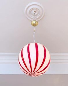 a red and white striped ball hanging from the ceiling