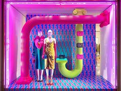 two mannequins are standing in front of a neon colored wall with the word love on it