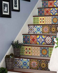 the stairs are decorated with colorful tiles and flower vases on each step, along with a hand holding a piece of paper