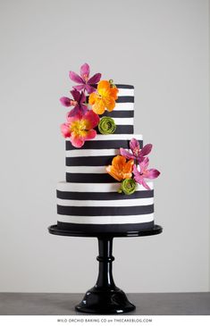 a black and white striped cake with flowers on top