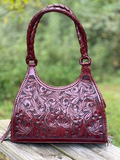 Introducing the ALLE Hand-Tooled Leather Hobo Bag "LUNA", a sophisticated and stylish way to store your belongings with an expertly crafted aesthetic. This luxury bag is hand-tooled with fine leather for an exquisite look and tangible elegance. Adorn yourself and your world with this timeless expression of beauty that is sure to make a statement. Size 15" W x 12 "H x 4" D (approximate) The Interior features a zip pocket and two side pocket Exterior design on the front and honeycomb on the back T Elegant Hand-tooled Satchel Shoulder Bag, Elegant Hand Tooled Shoulder Bag For Daily Use, Luxury Formal Hand-tooled Shoulder Bag, Elegant Hand-tooled Satchel Bag, Elegant Hand-tooled Top Handle Shoulder Bag, Elegant Hand Tooled Satchel For Travel, Elegant Hand-tooled Satchel For Travel, Formal Hand Tooled Shoulder Bag, Elegant Hand Tooled Shoulder Bag For Travel