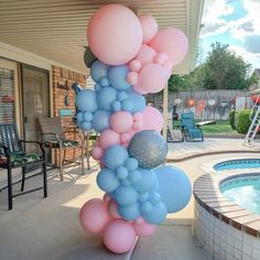 a bunch of balloons that are in front of a pool and some chairs on the patio