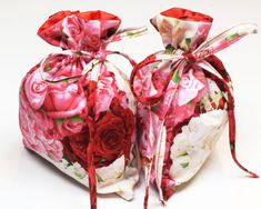 two bags with red and white flowers on them sitting next to each other in front of a white background