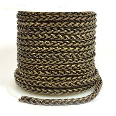 a spool of braiding rope on a white surface with a chain attached to it