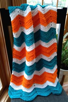 a crocheted blanket sitting on top of a chair