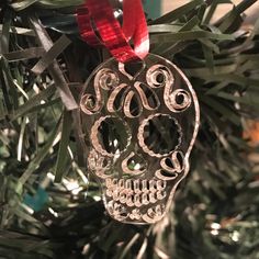 a glass ornament hanging from a christmas tree with red ribbon on it's head