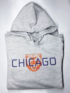 Represent Chicago Football with this stylish embroidered hoodie. Heather Gray Hooded sweatshirt with embroidered design. The perfect Comfort and coziness to watch your Bears! Perfect Idea for a Father or fathers Day Gift, Guys Gift, Brother, Dads, Grandfather, Grandpa, Husband, Male, Man, boy or boys, Son, Student, Teacher, Uncle, Dudes, and a perfect Christmas Present! Unisex Sizes  8.5 oz. 80/20 ring-spun cotton/polyester blend 3-end fleece with 100% cotton face Generous fit Fleece lined hood Chicago Bears Hoodie, Embroidered Hoodie, Embroidered Sweatshirts, Embroidered Design, Mens Gifts, Hooded Sweatshirts, Shirt Style, Chicago, Crew Neck Sweatshirt