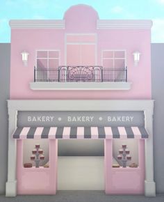 the front of a bakery with pink and white awnings on it's windows