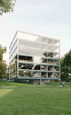 an architectural rendering of a glass building in the middle of a grassy area with people walking around