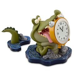 a clock with an alligator on it is sitting on a blue base and has its mouth open