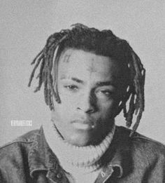 a black and white photo of a young man with dreadlocks on his head