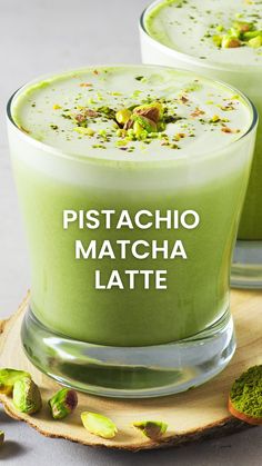 two glasses filled with matcha latte and topped with pistachio