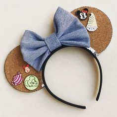 a mickey mouse ears with some decorations on it's head and a blue bow