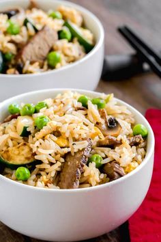 two white bowls filled with rice and vegetables