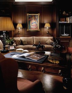 a living room filled with lots of furniture next to a lamp and painting on the wall