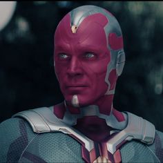 a close up of a person wearing a red and silver suit with blue eyes looking at the camera