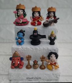 there are many small figurines on top of a white block with chess pieces