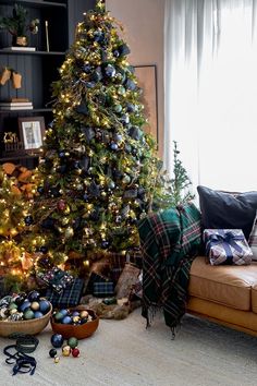 a living room with a christmas tree in the corner and other decorations on the floor