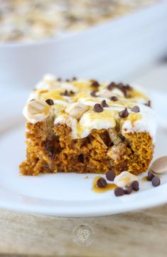 a piece of carrot cake with white frosting and pistachios on top