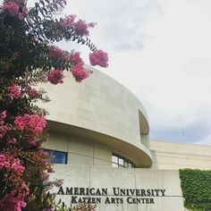 the american university of kaleen arts center building with pink flowers growing on it's side