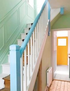 the stairs are painted blue and white with a yellow door in the hallway next to them