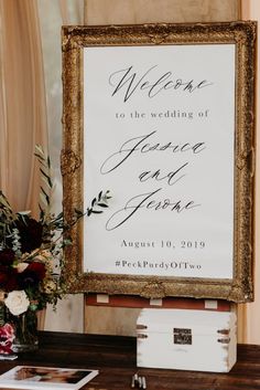 a wedding welcome sign on a table with flowers