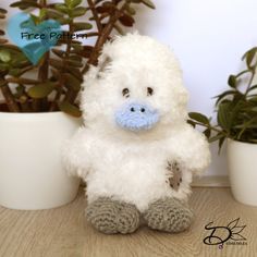 a white stuffed animal sitting next to potted plants